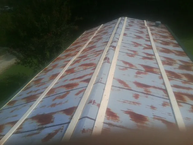 Rusted metal roof panels with new wood purlins before replacement — Storm Damage Roof Repair in Ypsilanti by Roofing Brothers